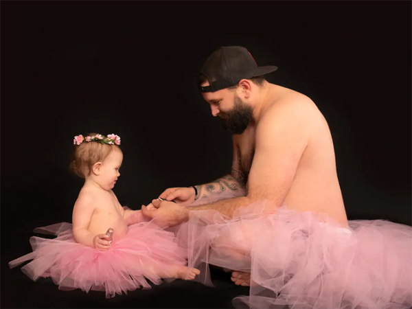 Dad and little daughter together wearing princess dresses for a photo