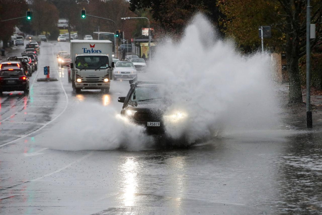 Cars plough through water in the flooded streets of central Auckland on Tuesday. Photo: New Zealand Herald via AP