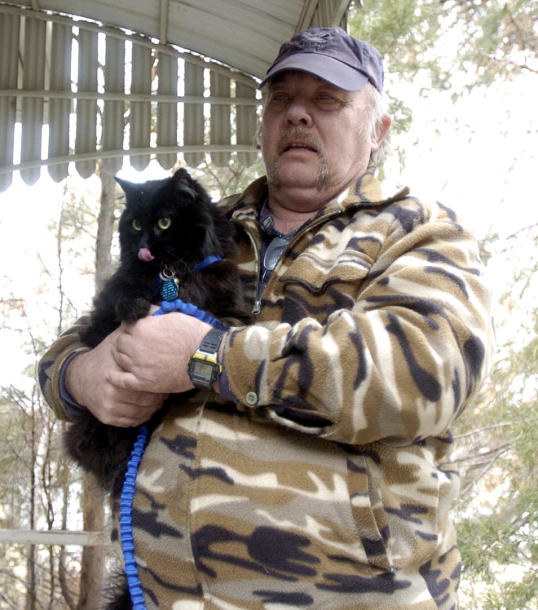 Greg Guy holds Schnautzie the cat.