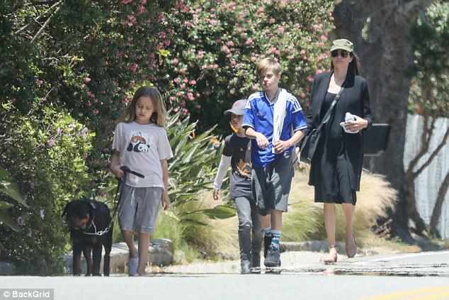 Keep pup: The much traveled family have been pictured with two other dogs in the recent past, having apparently adopted the animals after making California their permanent home; they are seen here with a different dog in May of this year